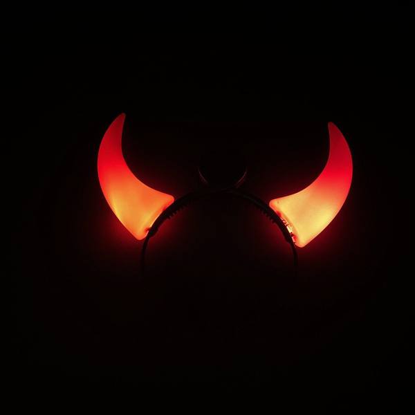 Serre-tête noir à grandes cornes de diable rouges allumées dans le noir
